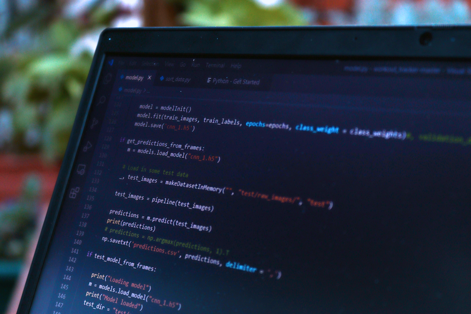database schema diagram, python code on screen, software developer workstation