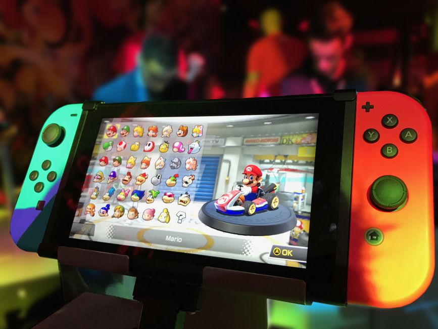 nintendo switch console, super mario figure, game controller