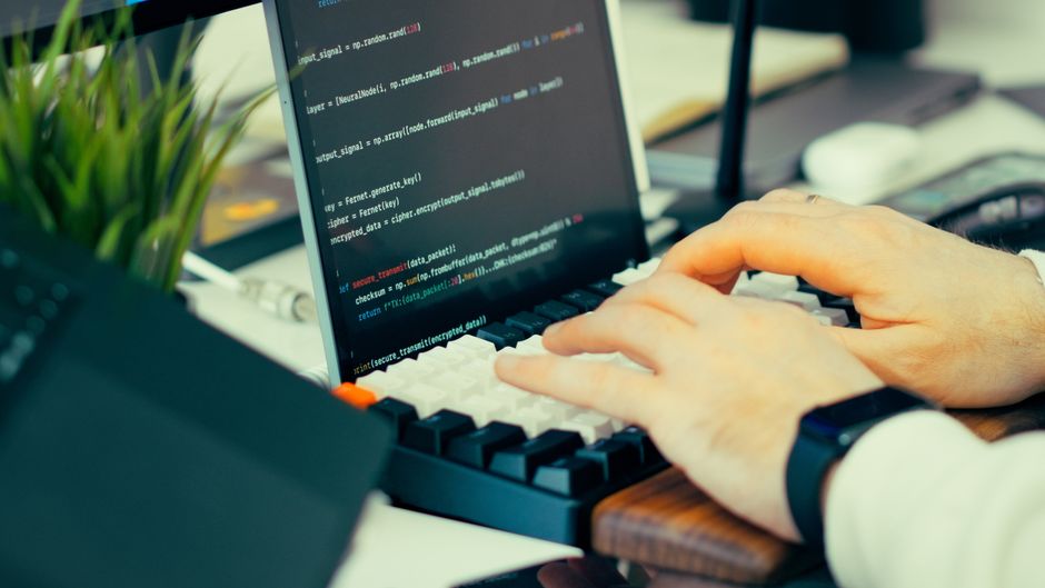 developer at computer terminal, hands off keyboard code screen