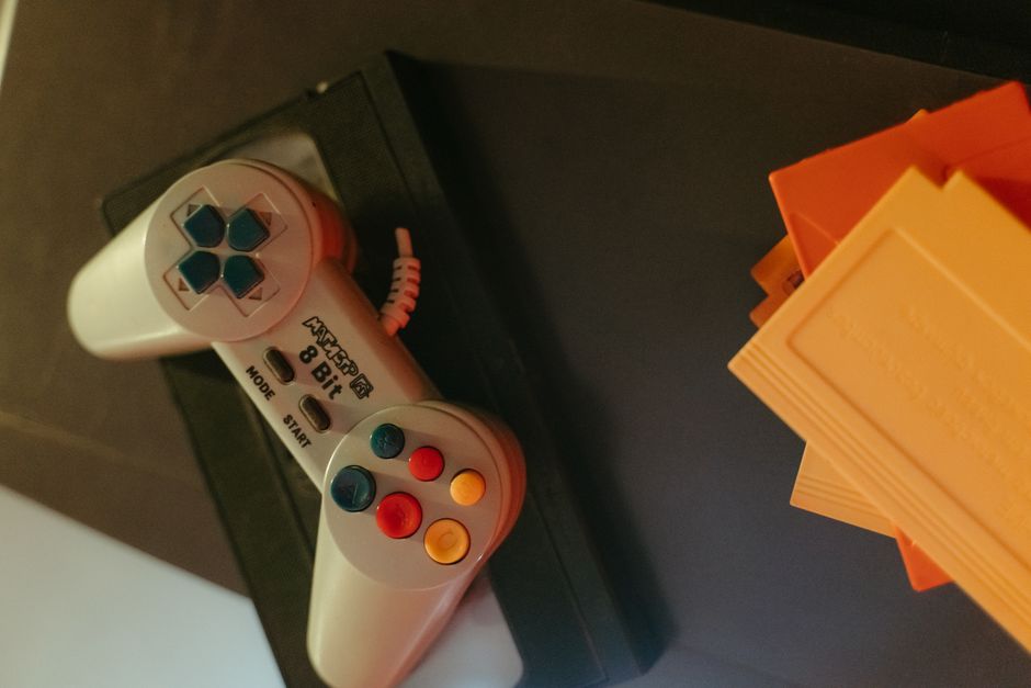 retro game controller, yellow cartoon car toy, old game console cartridge
