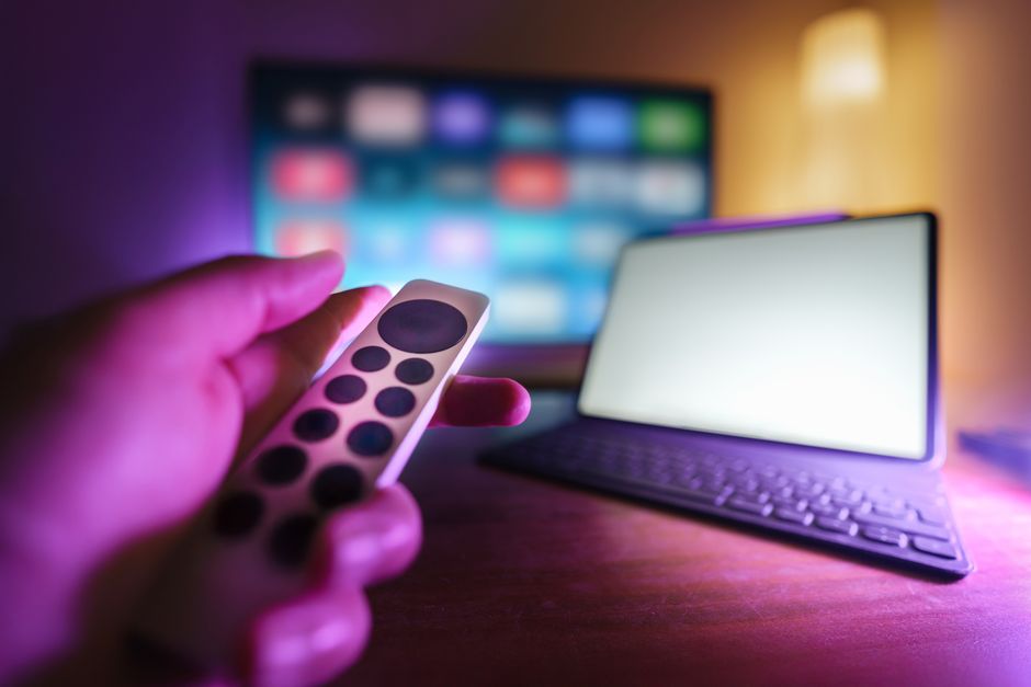 neon miami skyline at night, game controller on couch, tv streaming interface