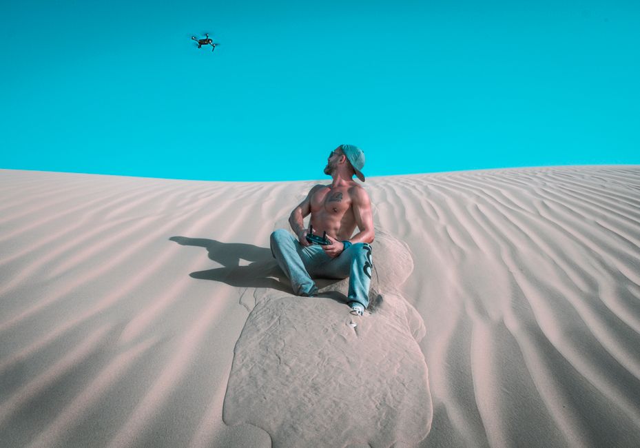 red sand desert dunes, game controller on dark desk