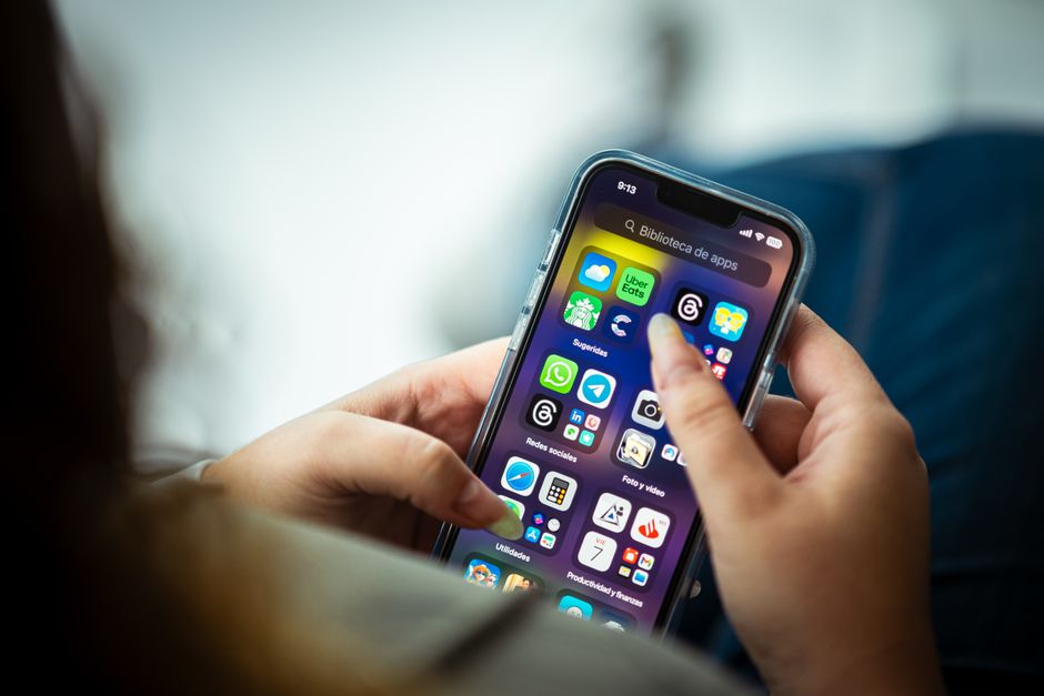smartphone app store screen, person using phone at desk