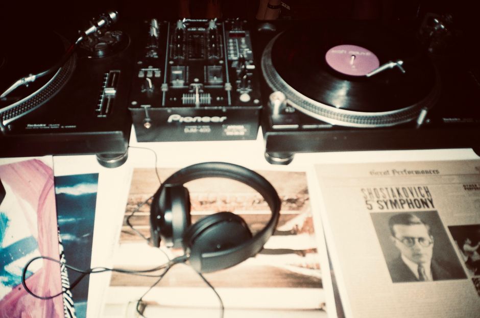 recording studio mixing board, vinyl records stack, headphones on soundboard
